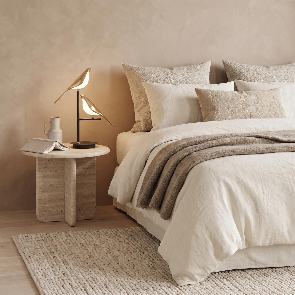 Avelle gold bird table lamp on a travertine bedside table