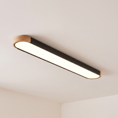 Imogen oval LED ceiling light, black 122 cm, oak wood ends, warm light on a white ceiling
