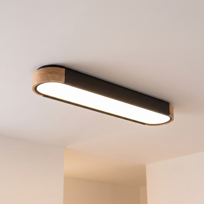 Imogen oval LED ceiling light, black 95 cm, oak wood ends, warm light on a white ceiling
