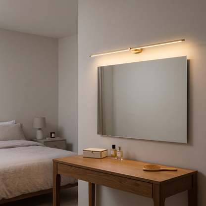 Valentina gold LED wall light – lit above a dressing table mirror