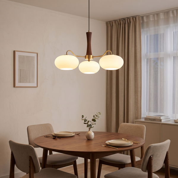 Cassius brass and wood chandelier – glowing above a round dining table