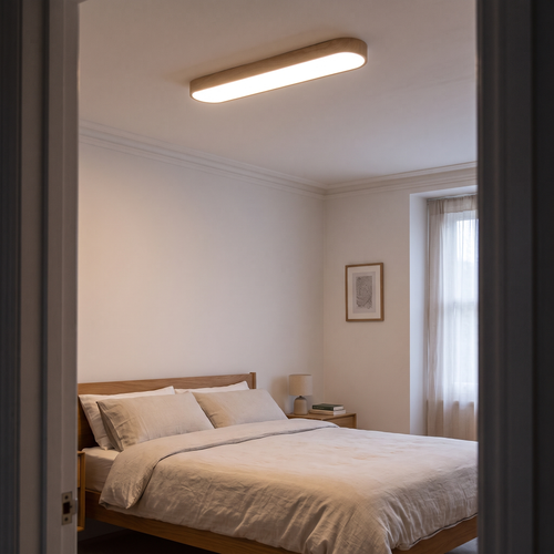 Elodie oval LED ceiling light – glowing on a bedroom ceiling