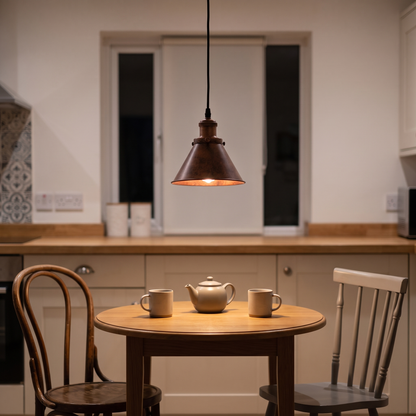 Carlotta copper cone pendant – glowing above a bistro table