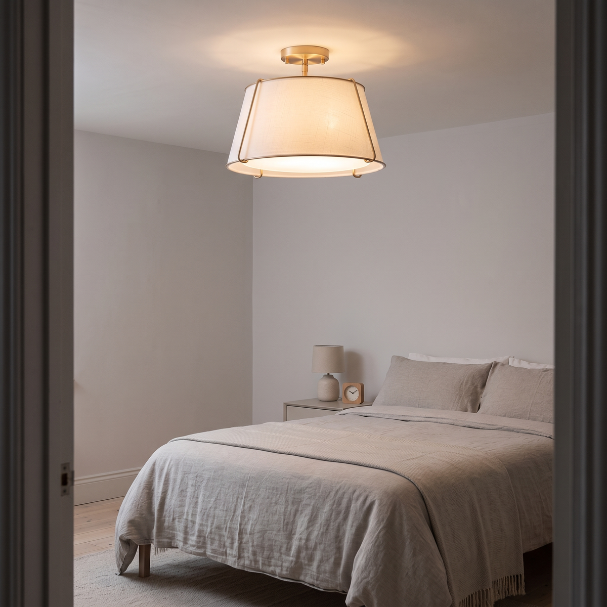 Theodora linen drum ceiling light – glowing in a bedroom