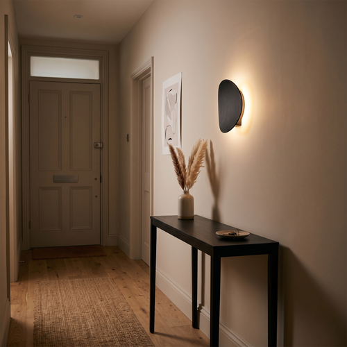 Camille round LED wall light – glowing in a hallway