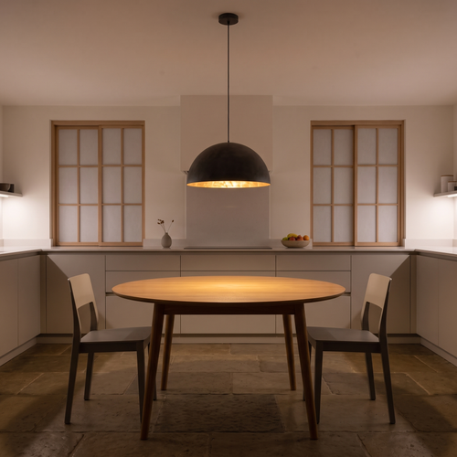 Octavia dome pendant with gold interior – glowing above a kitchen table