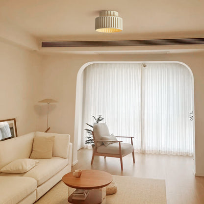 Colette ribbed resin ceiling light – in beige in a living room with an arch