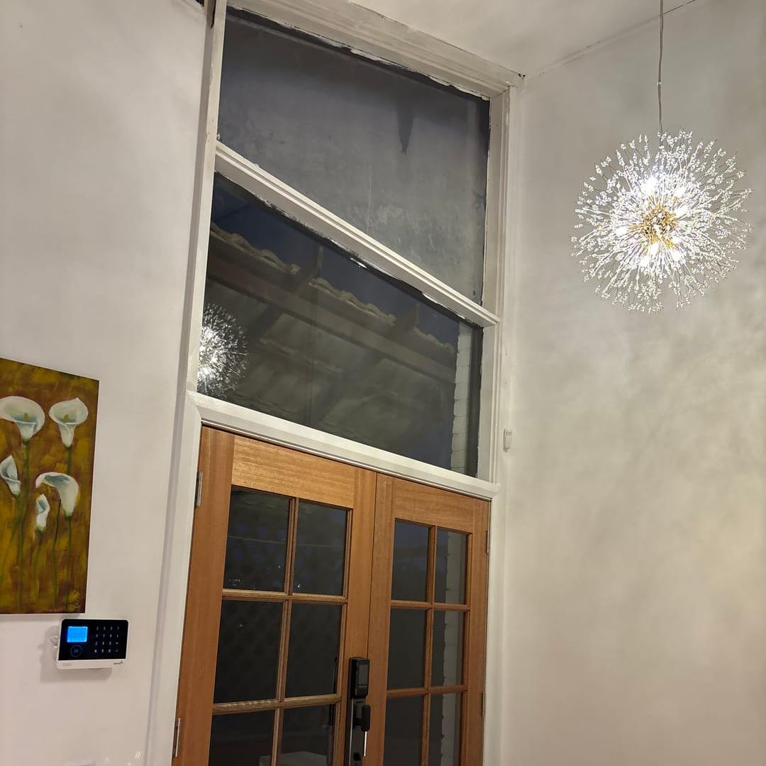 Delphine firework crystal chandelier – by a door with dark wood trim