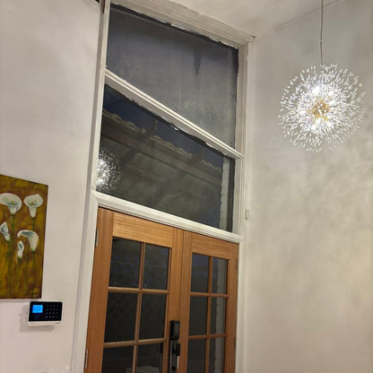 Delphine firework crystal chandelier – by a door with dark wood trim