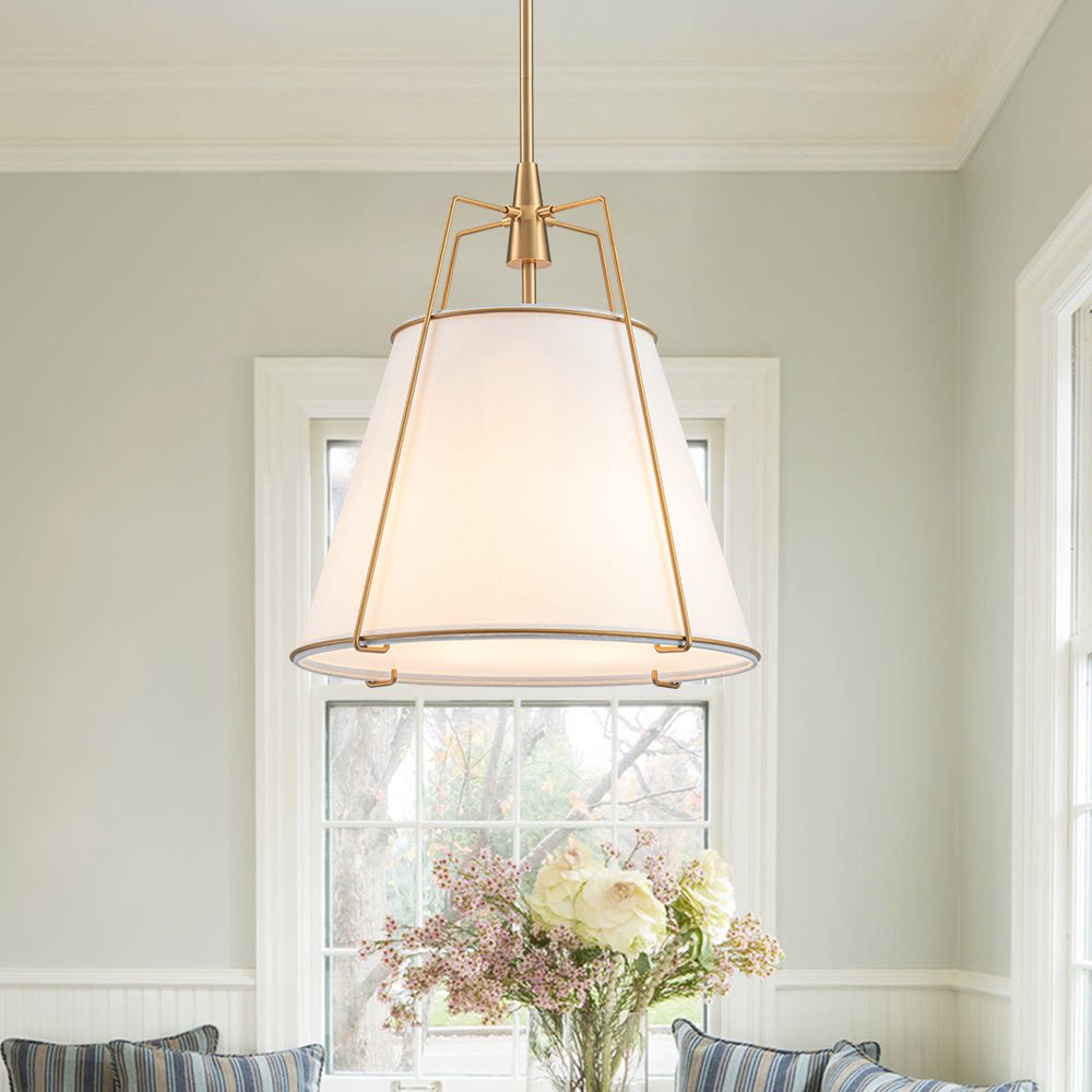 Ophelia tapered linen pendant – white shade with brass frame by a window