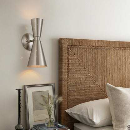 Stellan hourglass wall light – in brass in a bedroom