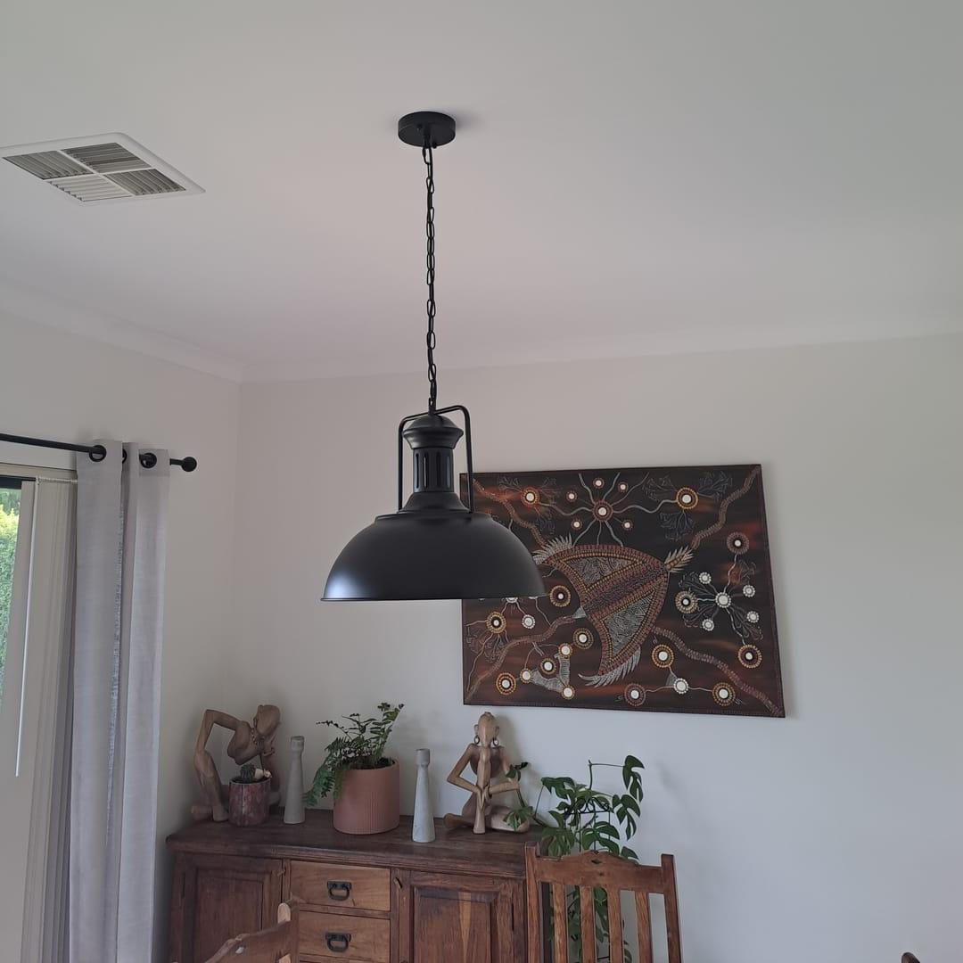 Hugo black dome pendant light above a wooden sideboard