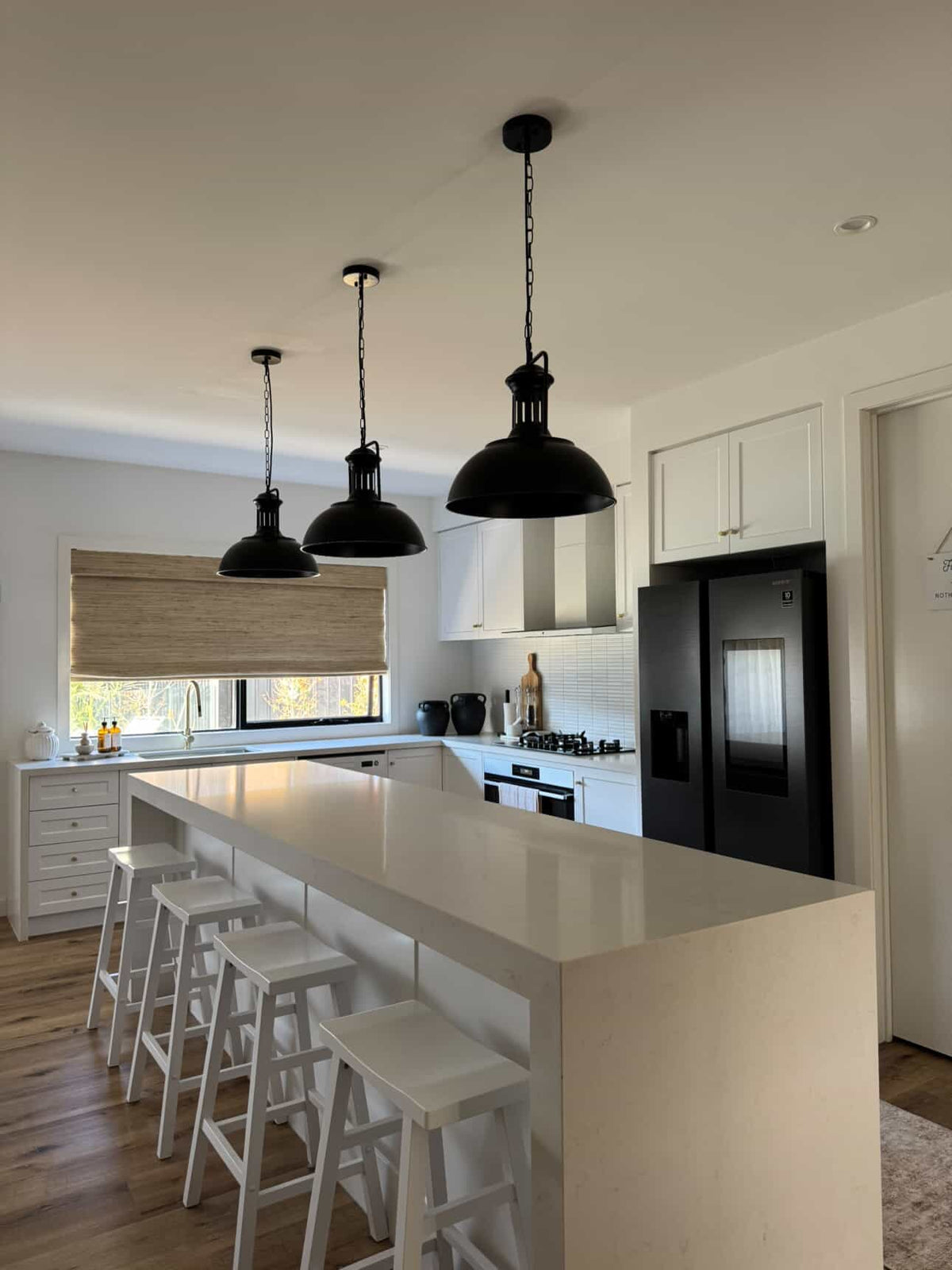 Hugo black dome pendant lights over a long kitchen island