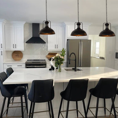 Hugo black dome pendant lights hanging above a kitchen island with black stools