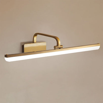 Cosima gold LED vanity light – glowing warm on a beige wall