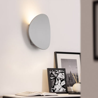 Camille round LED wall light – in white, lit beside black
