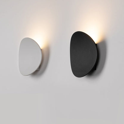Camille round LED wall light – in white and black, lit on a wall
