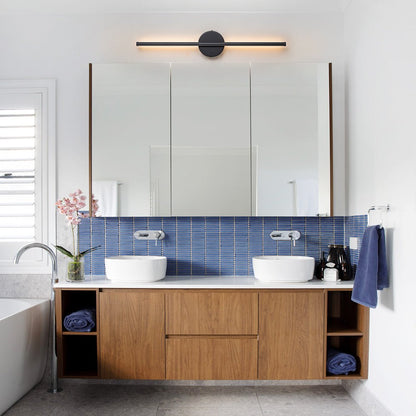 Sebastian linear LED wall light – in black above a bathroom mirror
