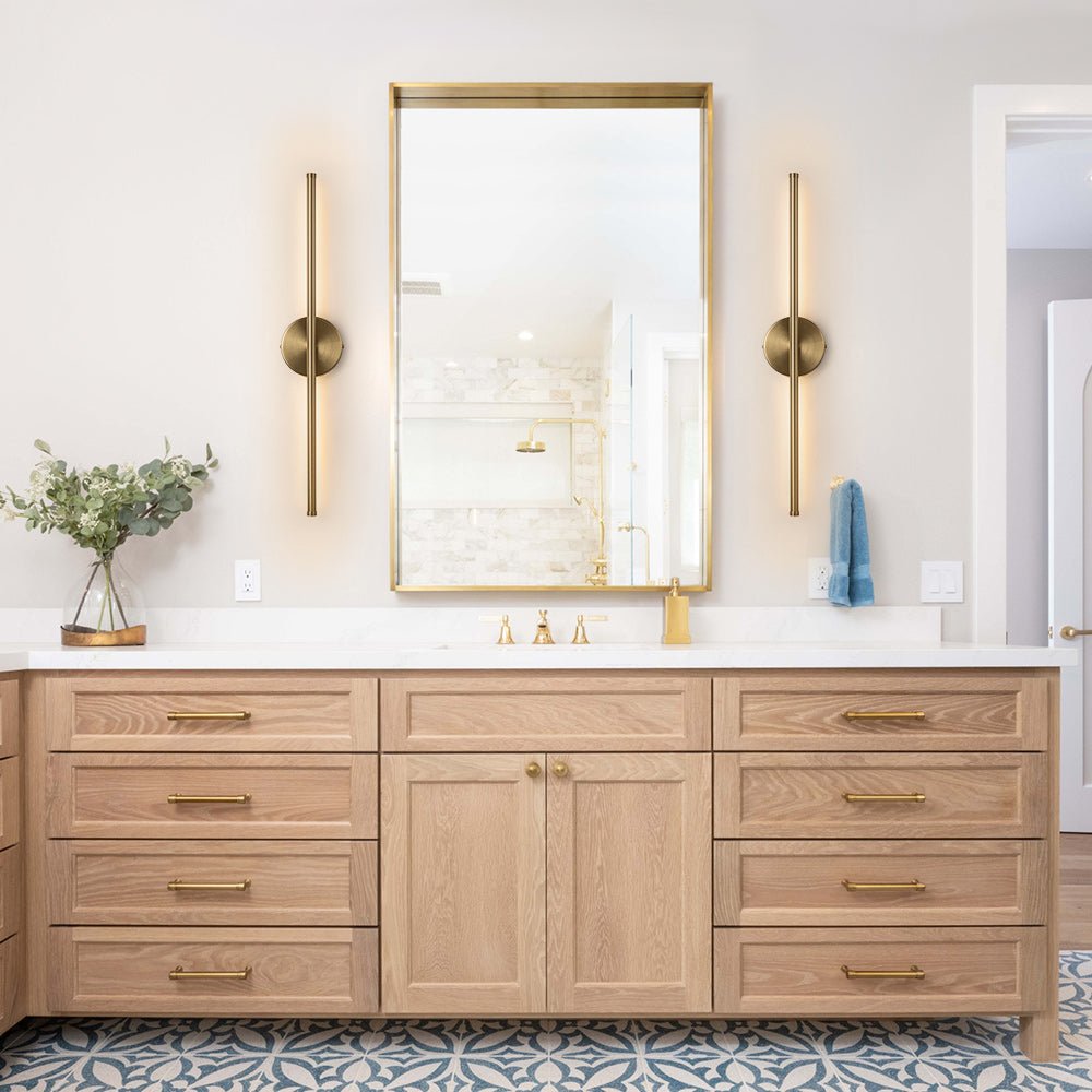 Sebastian linear LED wall light – pair in brass beside a bathroom mirror