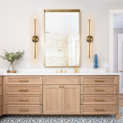 Sebastian linear LED wall light – pair in brass beside a bathroom mirror