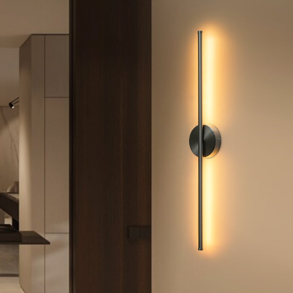 Sebastian linear LED wall light – in nickel, lit on a dark wall