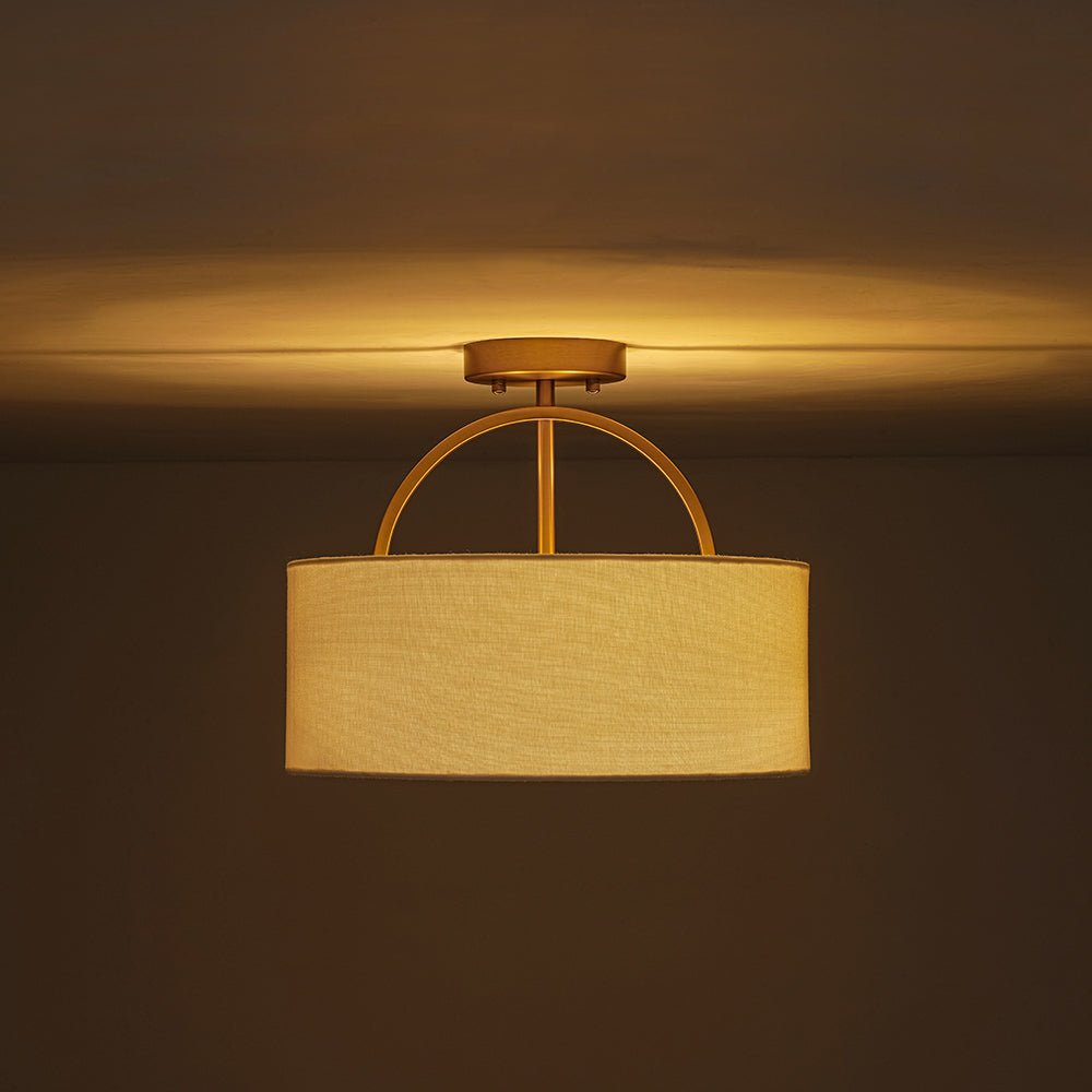 Isadora linen drum ceiling light – lit with a warm glow
